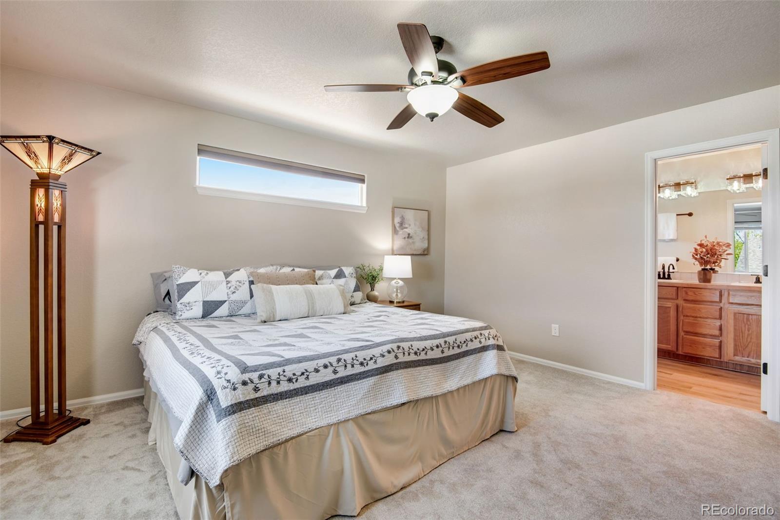 7035 McClellan Road Wellington, CO 80549 - Photo 29 of 43 a bedroom with a bed and a chandelier