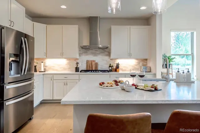 a kitchen with stainless steel appliances granite countertop a refrigerator and a stove top oven
