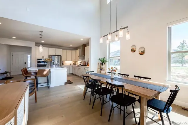 a dining area with a table chairs and a kitchen view