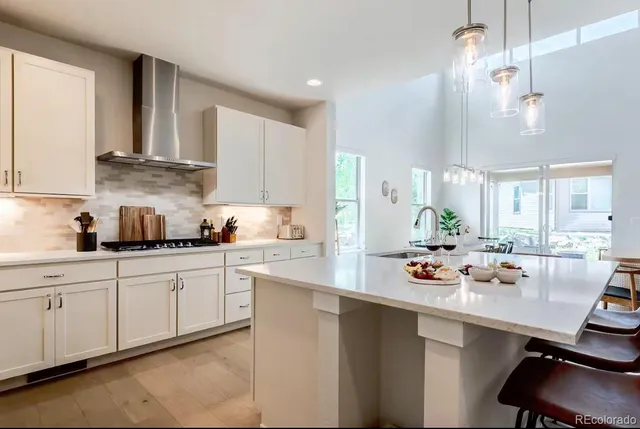 a kitchen with white cabinets and window