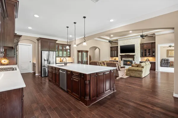 a large kitchen with stainless steel appliances granite countertop a large center island and a wooden floor