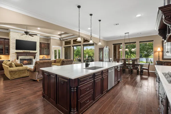 a large kitchen with lots of counter space a sink appliances and living room view