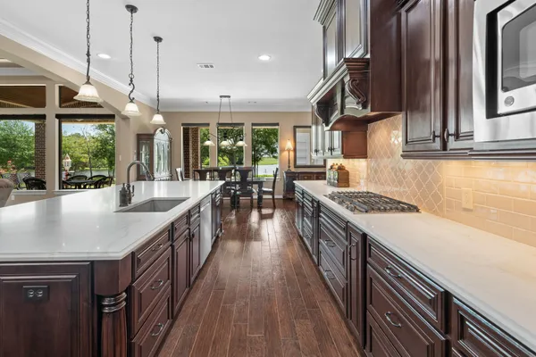 a kitchen with sink stove and wooden floor
