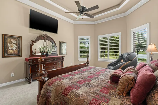 a bed room with a bed a television and a large window