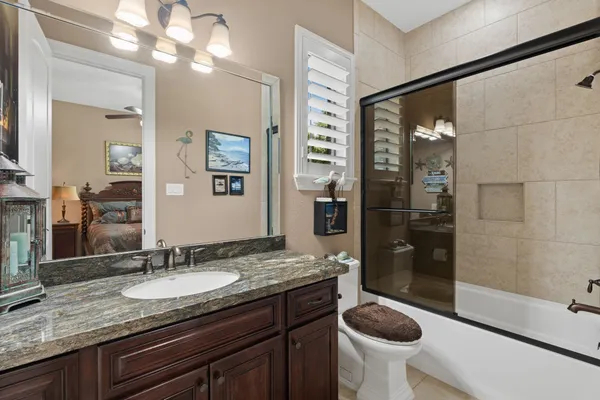 a bathroom with a granite countertop sink toilet and shower