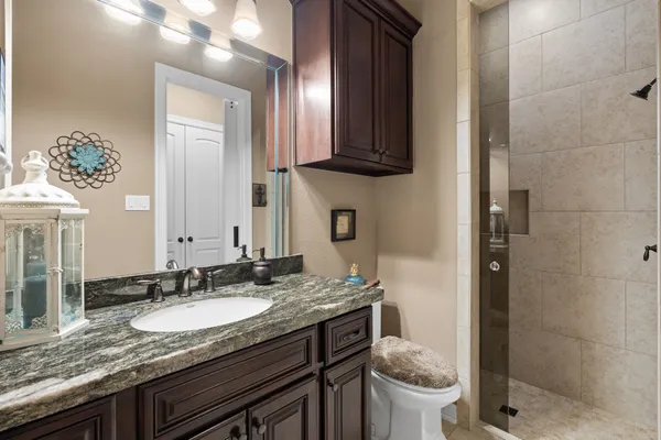 a bathroom with a granite countertop sink and a mirror