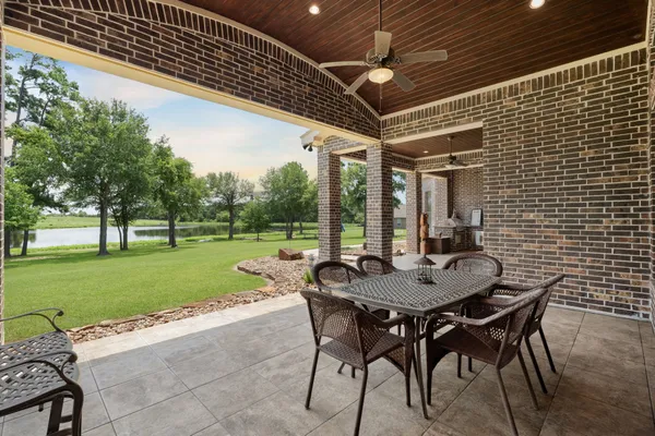 a view of a patio with a table and chairs and a barbeque