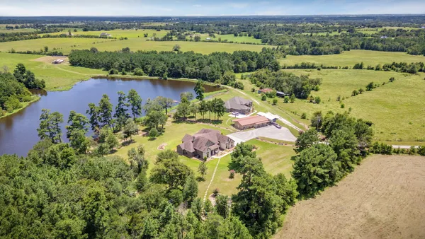 an aerial view of lake residential house with swimming pool and green space