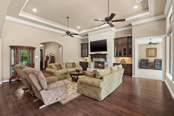 a living room with furniture a ceiling fan and a flat screen tv