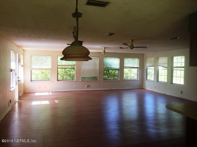 4155 Pinto Road Middleburg, FL 32068 - Photo 3 of 38 an empty room with wooden floor and windows