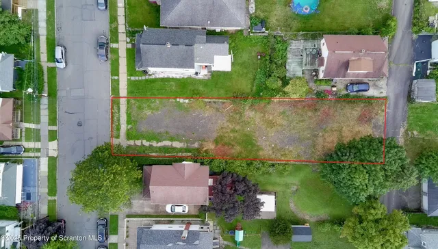 an aerial view of residential houses with outdoor space and street view