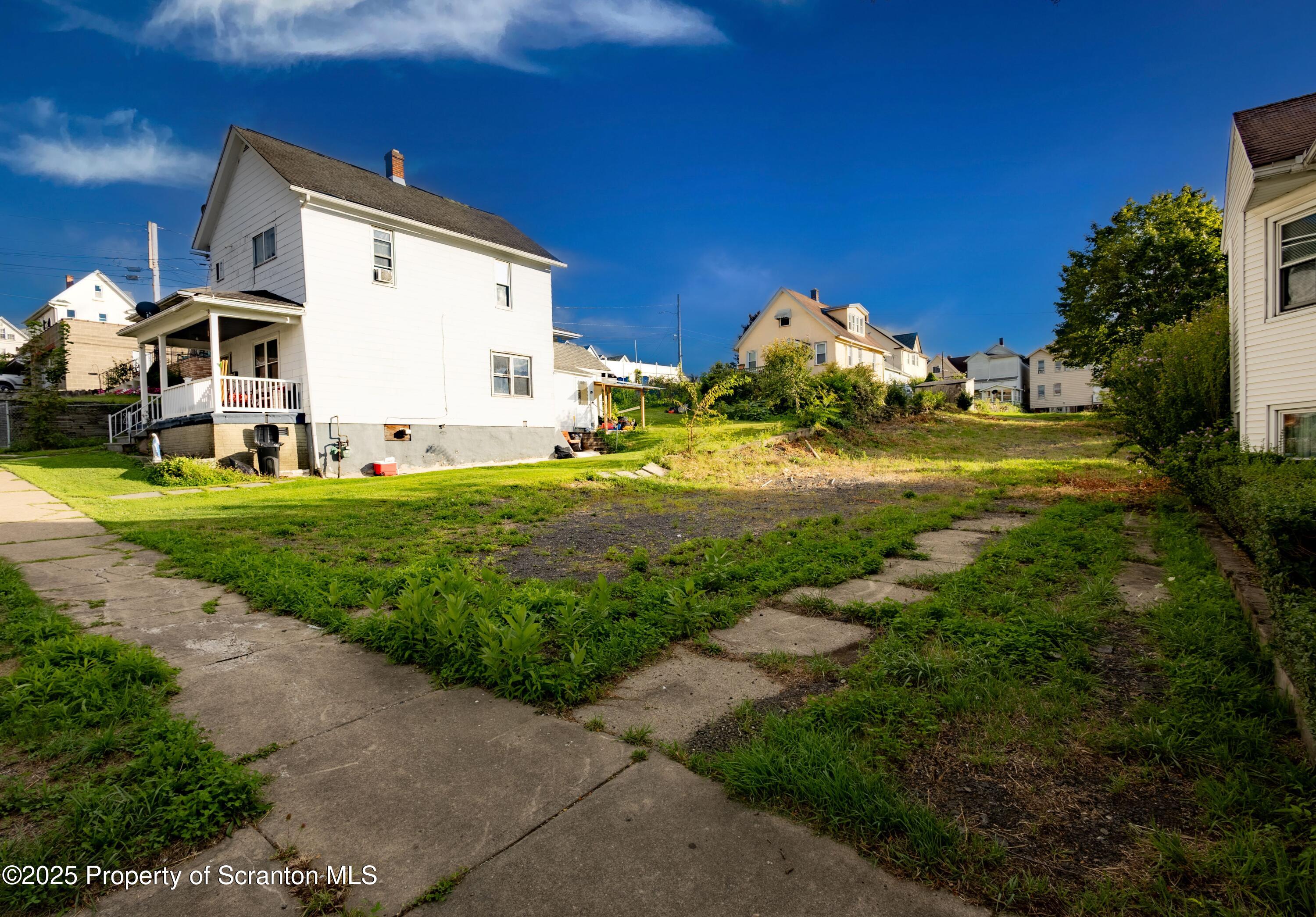 728 Alder Street Scranton, PA 18505 - Photo 3 of 13 a view of a white house with a yard