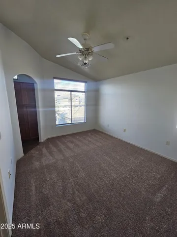 an empty room with windows and fan