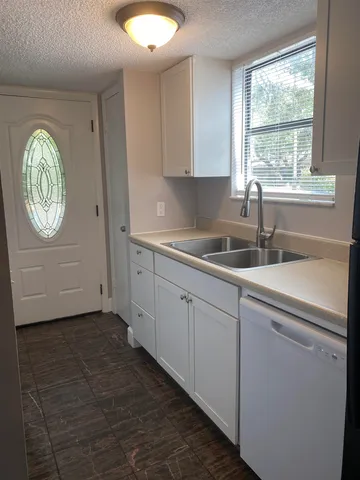 a kitchen with a sink cabinets and window