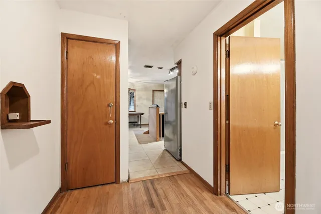 a view of a hallway with wooden floor and closet
