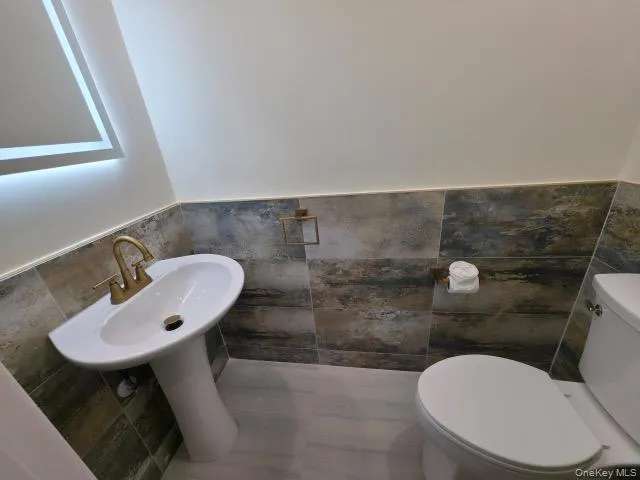 a bathroom with a sink a toilet and a mirror