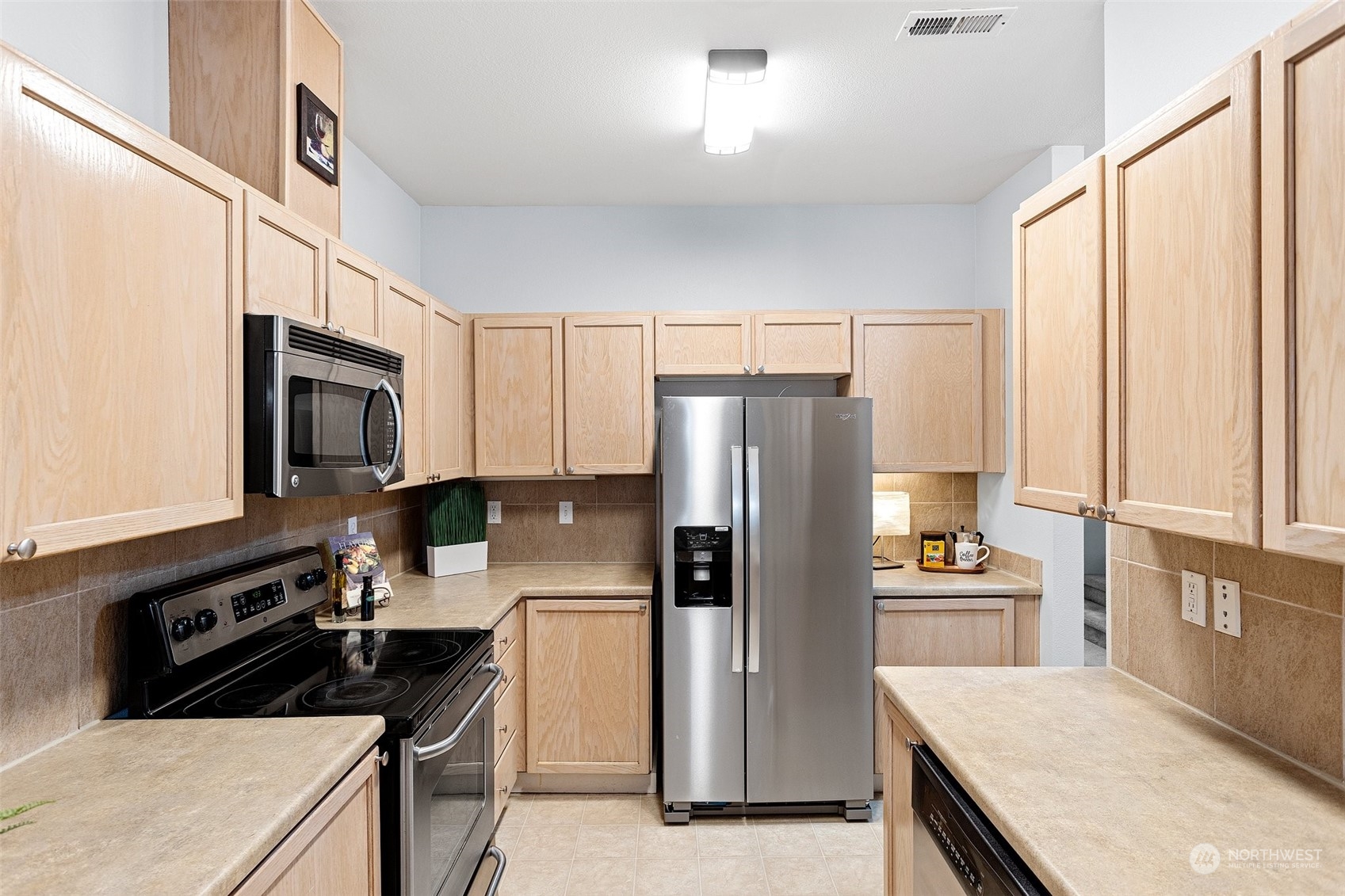 18930 Bothell Everett Highway, Unit L102 Bothell, WA 98012 - Photo 12 of 28 a kitchen with granite countertop a refrigerator stove and microwave