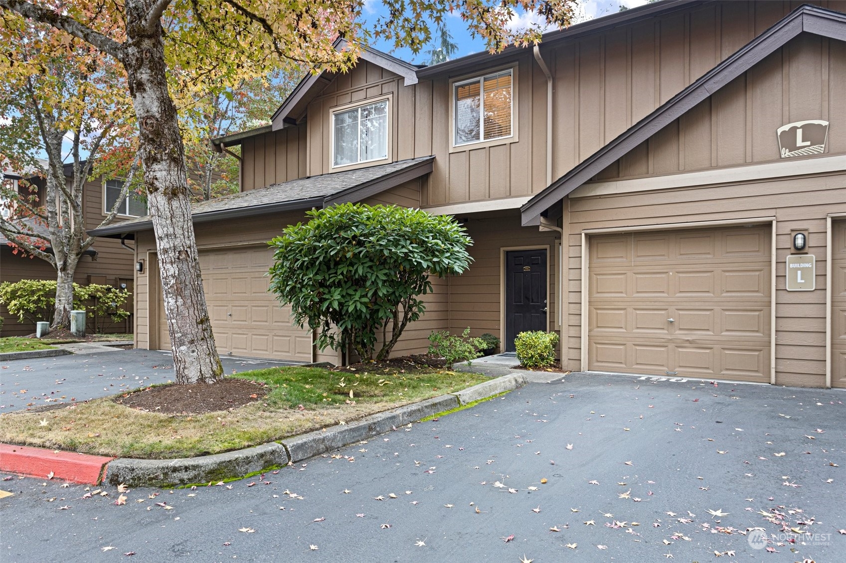 18930 Bothell Everett Highway, Unit L102 Bothell, WA 98012 - Photo 3 of 28 a front view of a house with a yard and garage