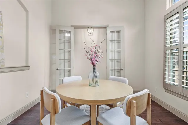 a kitchen with stainless steel appliances granite countertop a table chairs and a refrigerator