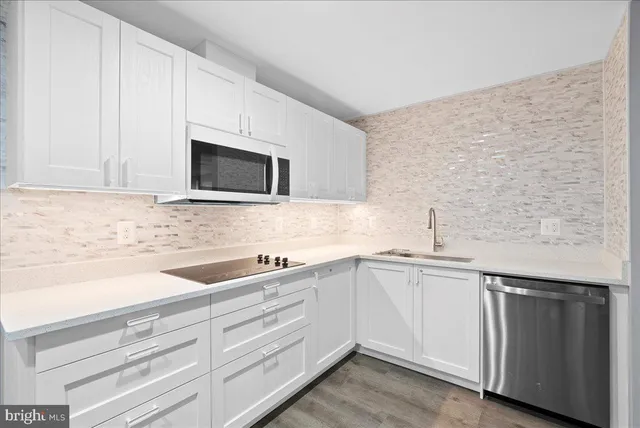 a kitchen with white cabinets and white appliances
