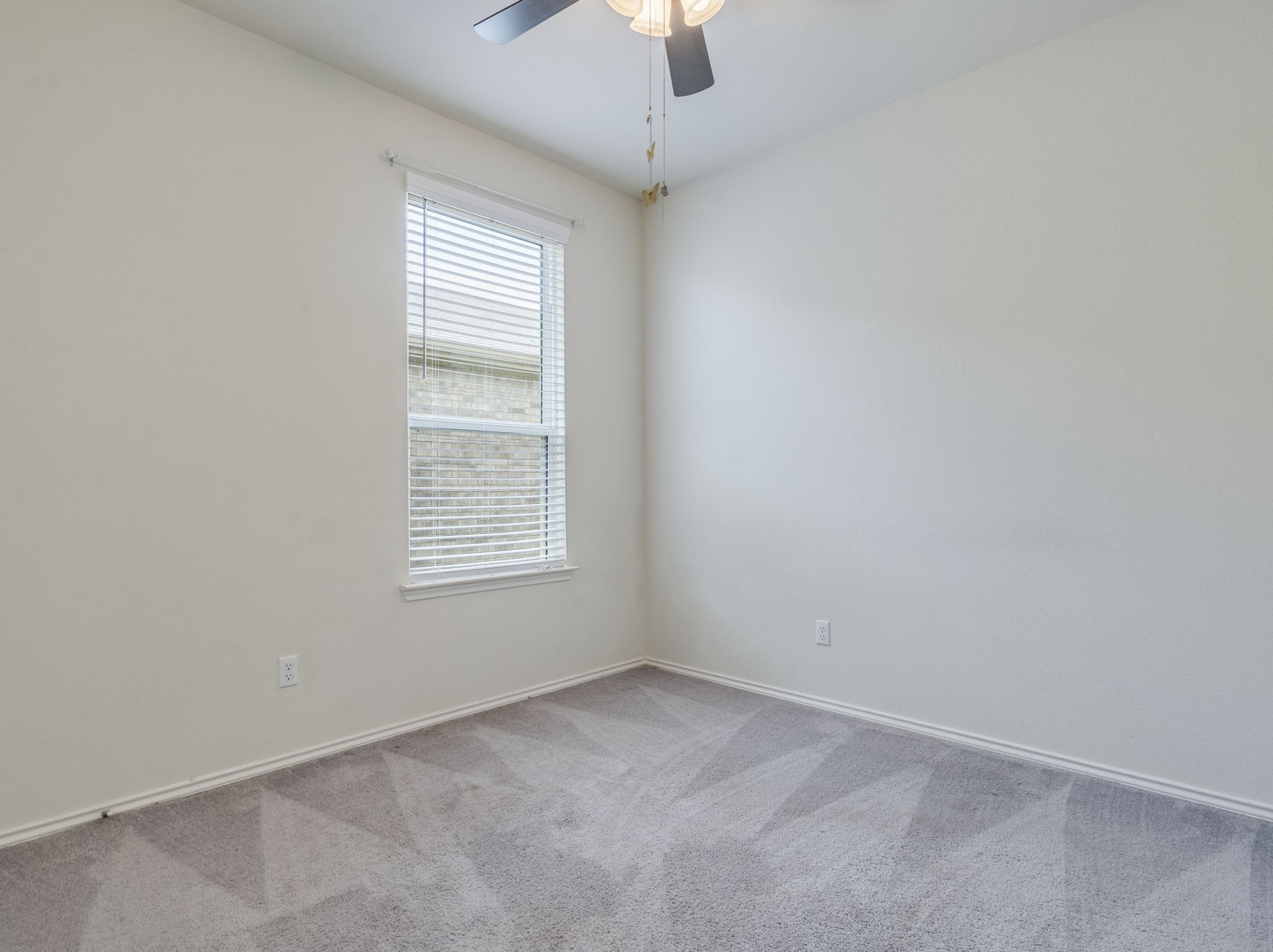 790 Pepperbark Loop Buda, TX 78610 - Photo 12 of 22 A well-lit bedroom offering plush carpeting and a bright window with blinds.
