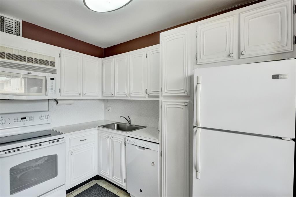 32 Colonial Club Drive, Unit 202 Boynton Beach, FL 33435 - Photo 12 of 38 a kitchen with white cabinets and white appliances