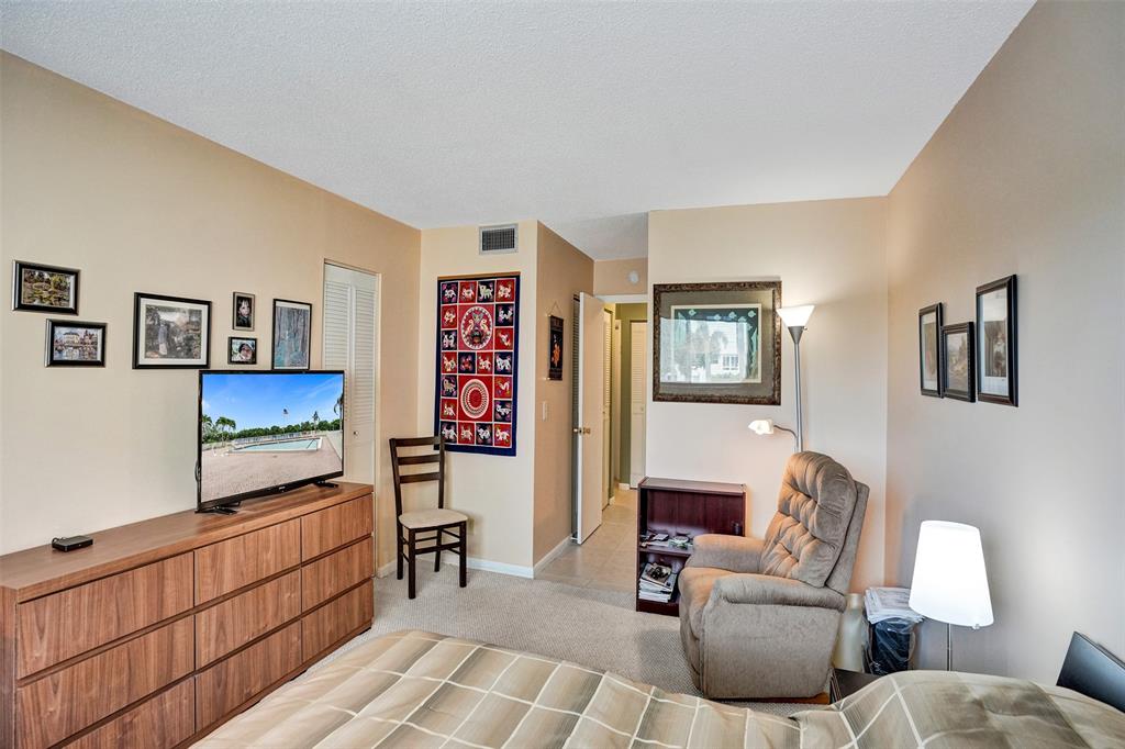 32 Colonial Club Drive, Unit 202 Boynton Beach, FL 33435 - Photo 17 of 38 a living room with furniture and a flat screen tv