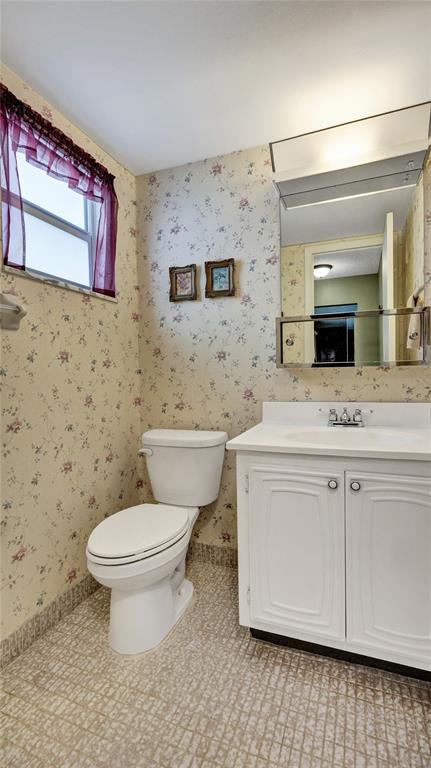 32 Colonial Club Drive, Unit 202 Boynton Beach, FL 33435 - Photo 24 of 38 a bathroom with a granite countertop toilet sink and mirror