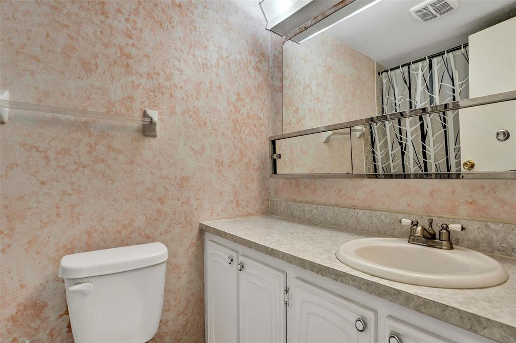 32 Colonial Club Drive, Unit 202 Boynton Beach, FL 33435 - Photo 25 of 38 a bathroom with a toilet a sink and mirror