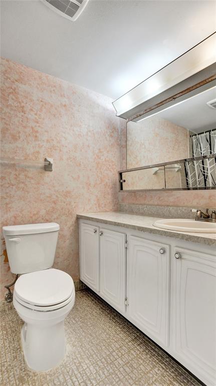 32 Colonial Club Drive, Unit 202 Boynton Beach, FL 33435 - Photo 26 of 38 a bathroom with a toilet a sink and mirror