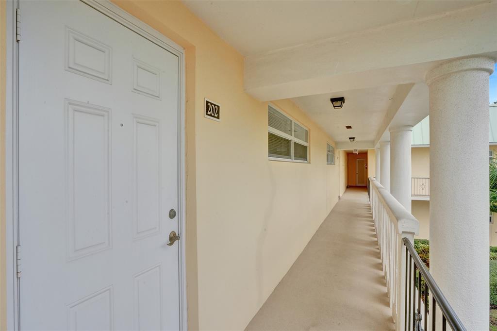 32 Colonial Club Drive, Unit 202 Boynton Beach, FL 33435 - Photo 27 of 38 a view of a hallway with wooden floor and entryway