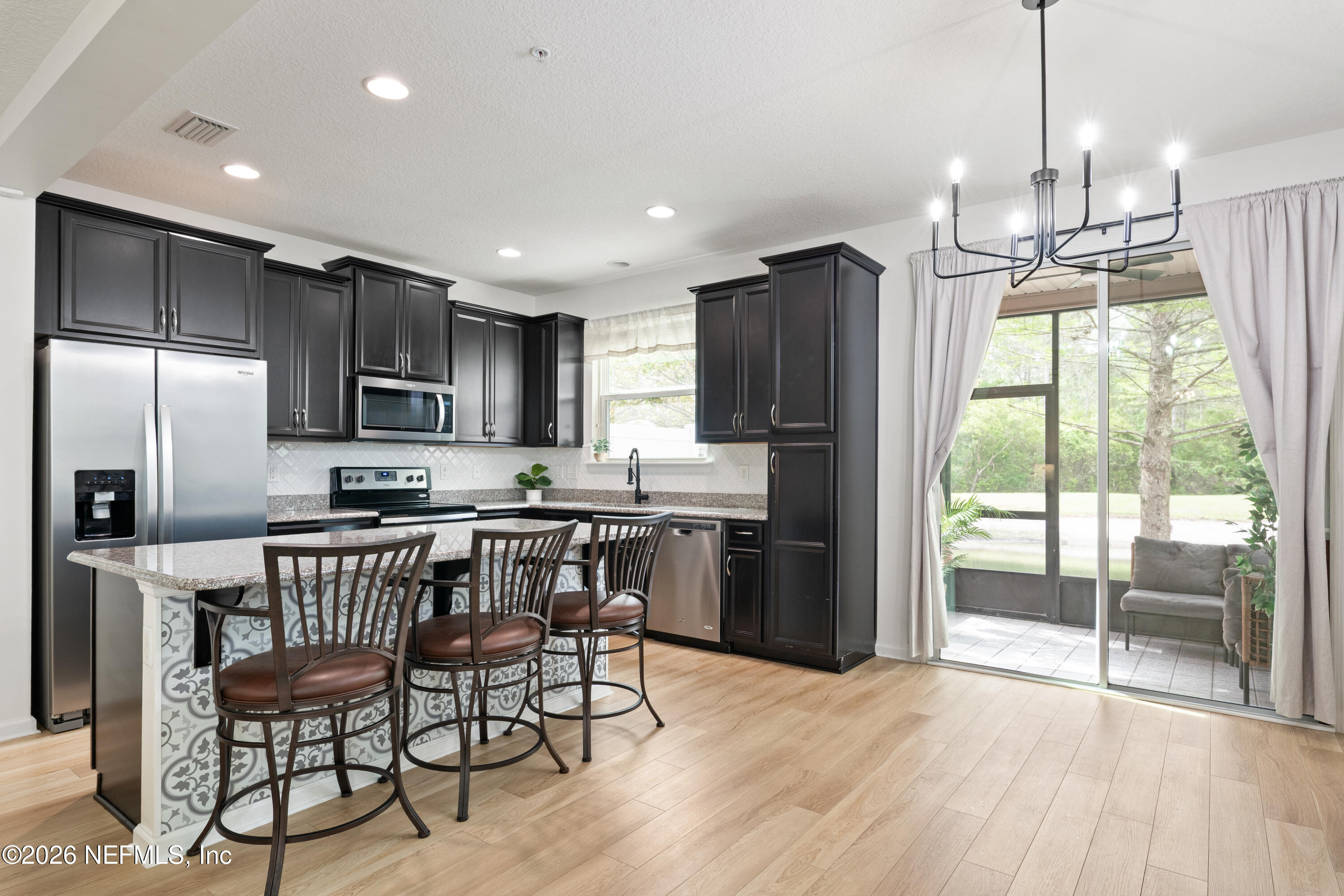 111 Paradas Place St. Augustine, FL 32092 - Photo 11 of 46 a kitchen with stainless steel appliances granite countertop a refrigerator a stove top oven a sink dishwasher a dining table and chairs with wooden floor