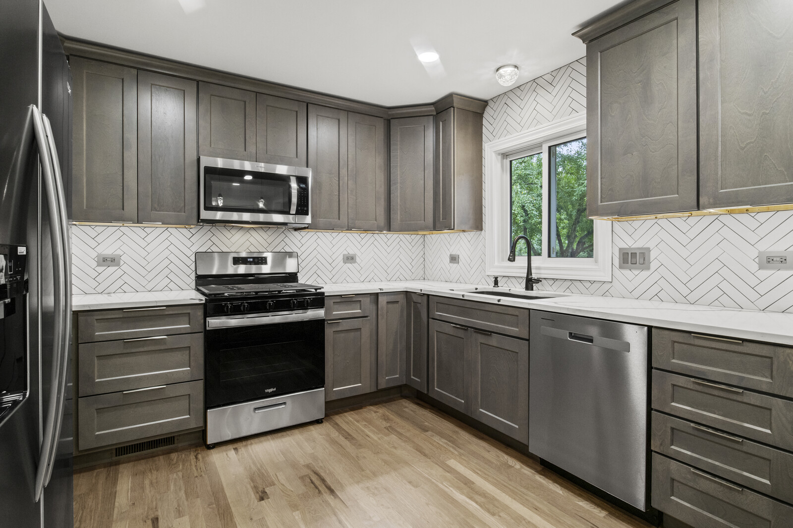 580 Geronimo Street Hoffman Estates, IL 60169 - Photo 3 of 28 a kitchen with stainless steel appliances granite countertop a stove a sink and a microwave