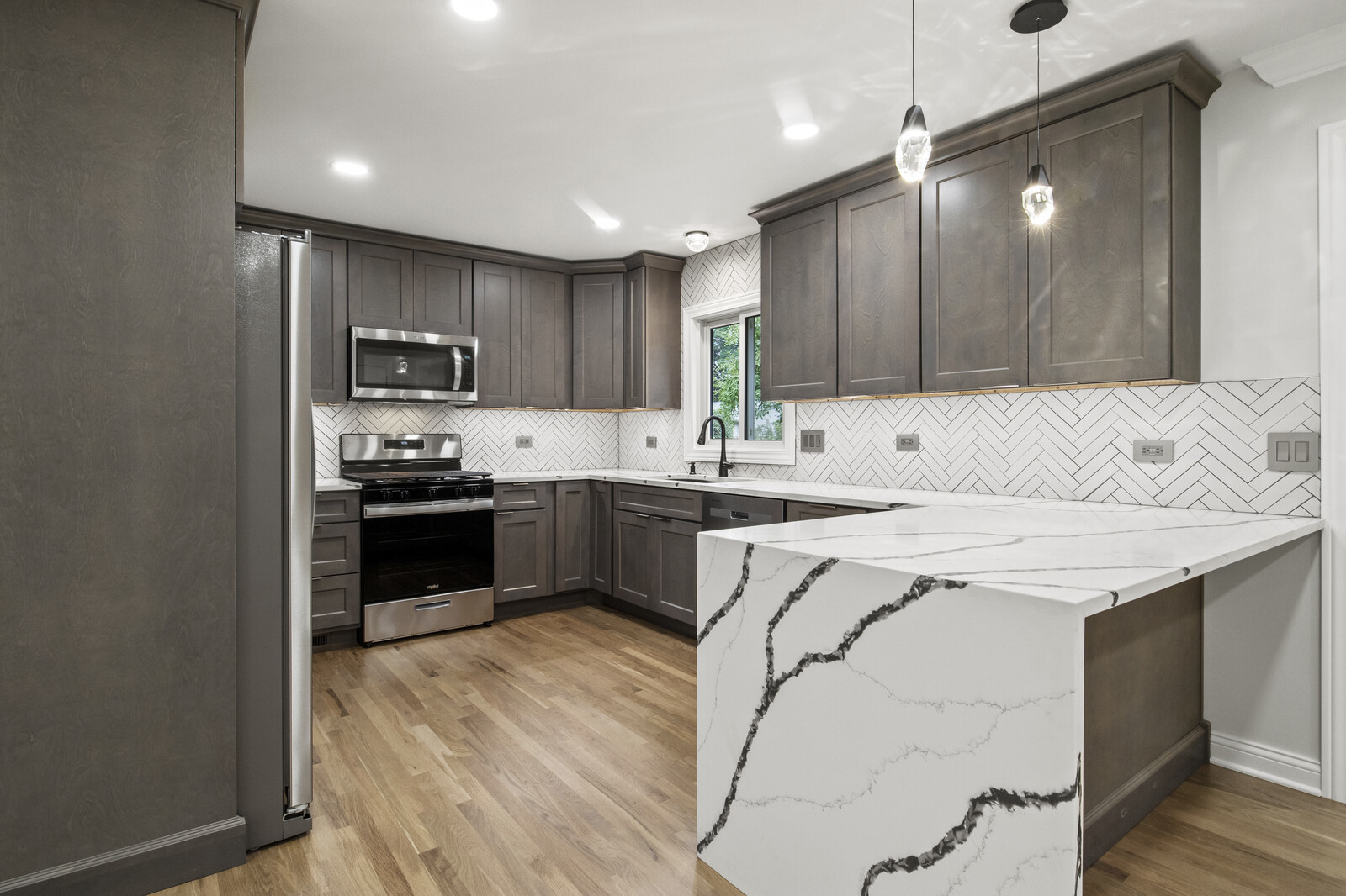580 Geronimo Street Hoffman Estates, IL 60169 - Photo 5 of 28 a kitchen with kitchen island a sink stainless steel appliances and cabinets