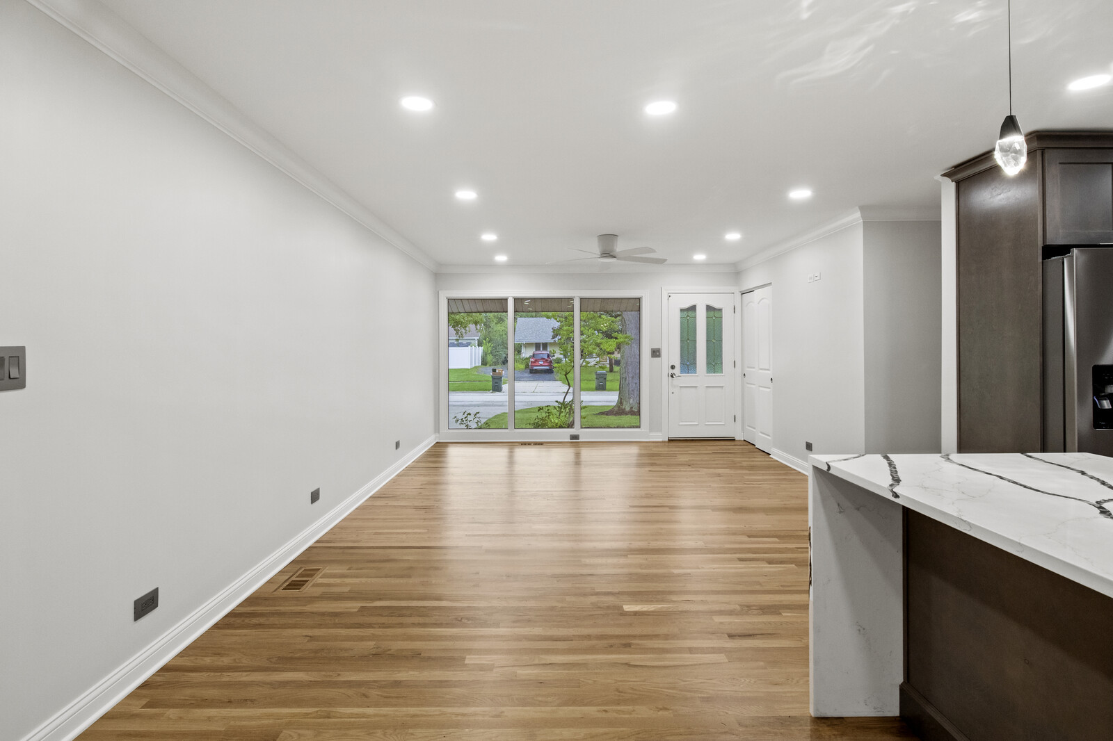 580 Geronimo Street Hoffman Estates, IL 60169 - Photo 8 of 28 a view of an empty room with wooden floor and a kitchen