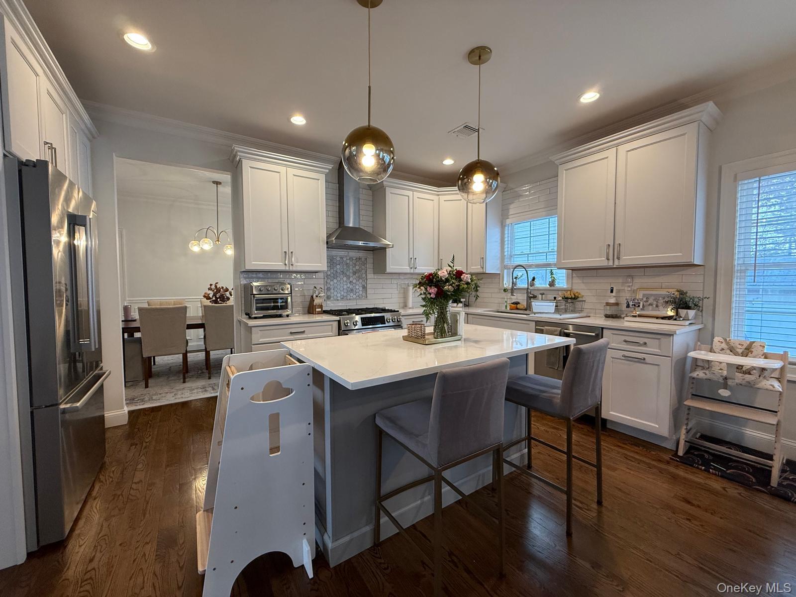 116 Winifred Drive Merrick, NY 11566 - Photo 12 of 40 a kitchen with stainless steel appliances kitchen island granite countertop a stove a sink a refrigerator and chairs with wooden floor