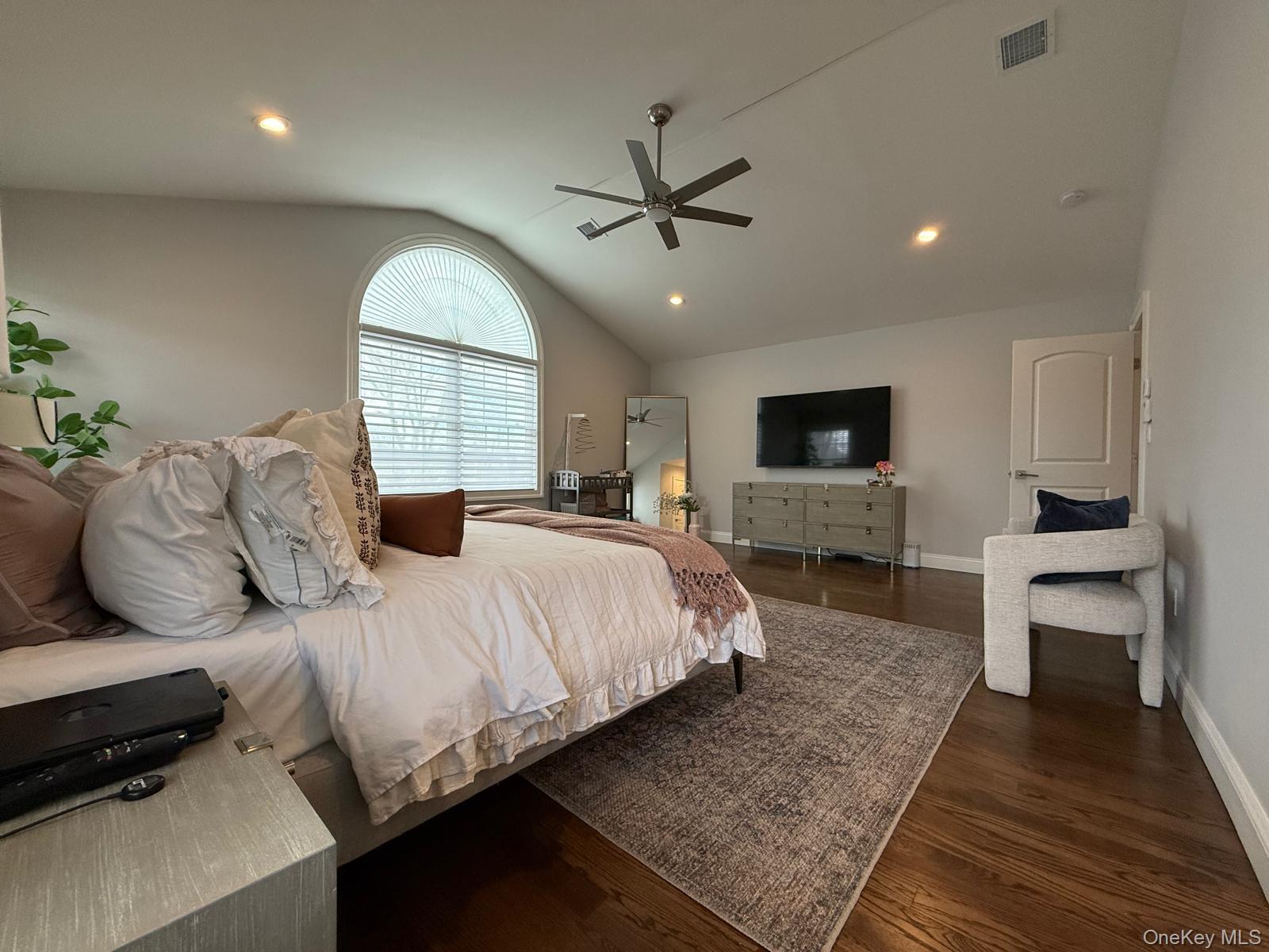 116 Winifred Drive Merrick, NY 11566 - Photo 19 of 40 a bedroom with a large bed and a flat screen tv