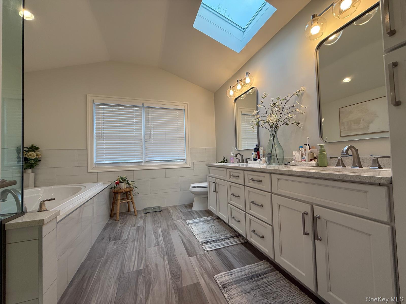 116 Winifred Drive Merrick, NY 11566 - Photo 24 of 40 a spacious bathroom with a double vanity sink a mirror and a bathtub