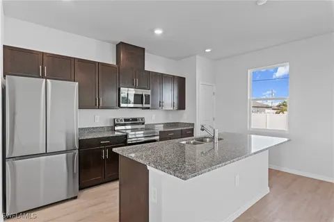 a kitchen with granite countertop kitchen island stainless steel appliances a table and chairs