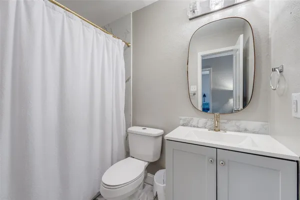 a bathroom with a toilet a sink and a mirror