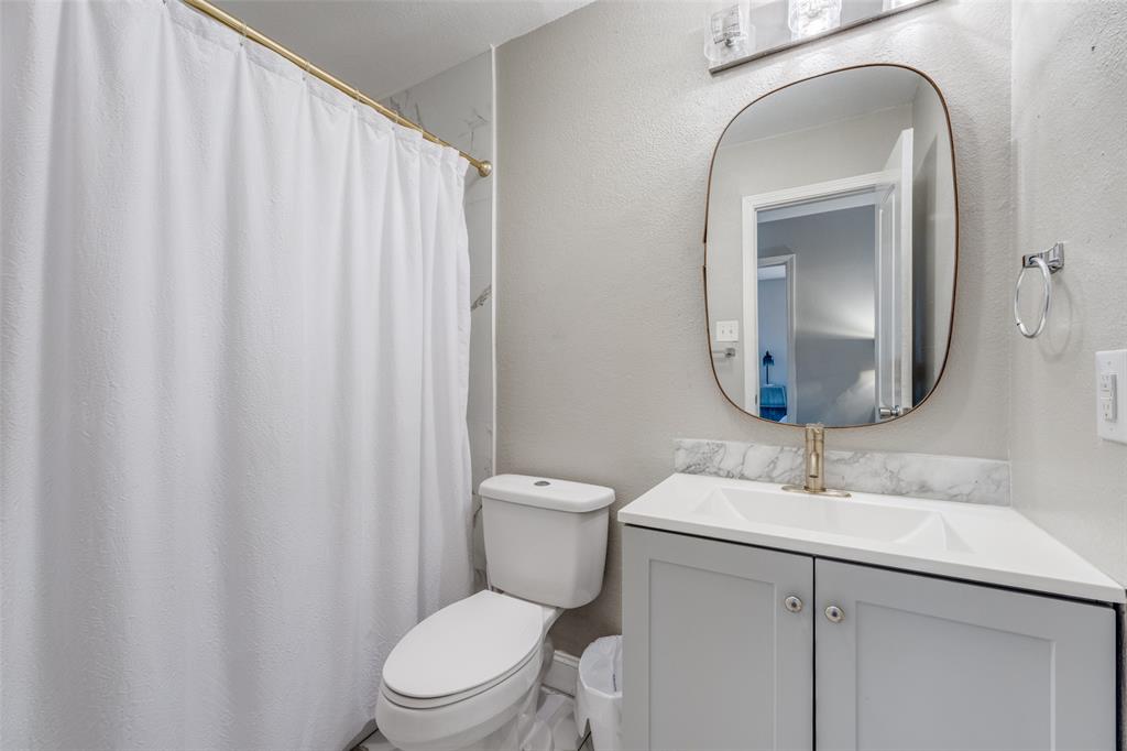 1222-1224 West Hunt Street, Unit 1222 Sherman, TX 75092 - Photo 21 of 23 a bathroom with a toilet a sink and a mirror