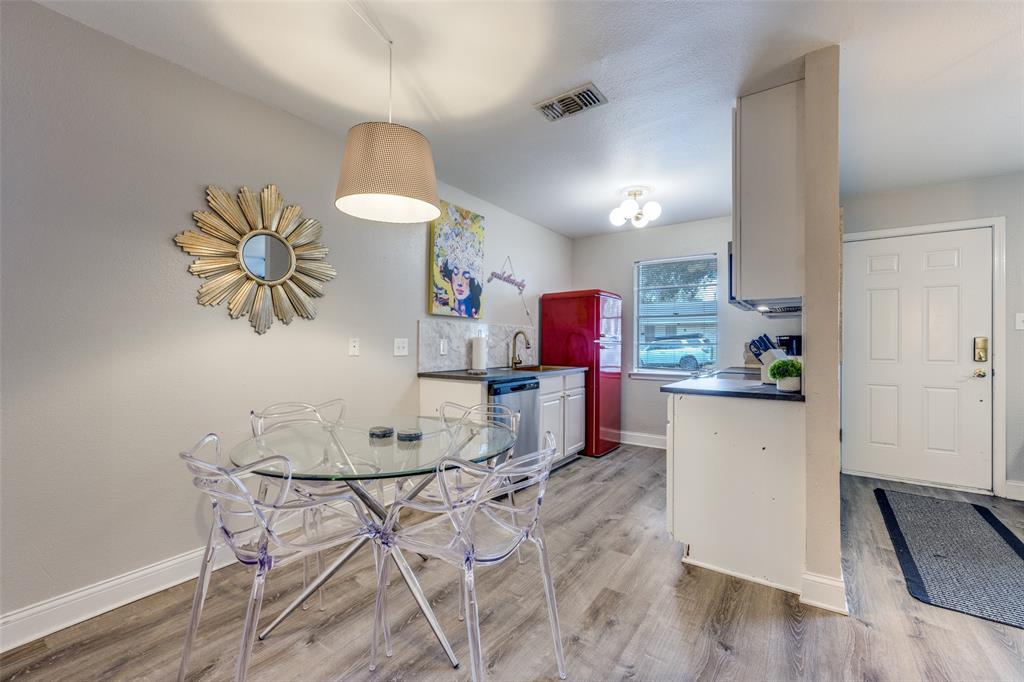 1222-1224 West Hunt Street, Unit 1222 Sherman, TX 75092 - Photo 8 of 23 a kitchen with stainless steel appliances a stove a refrigerator and a dining table with wooden floor