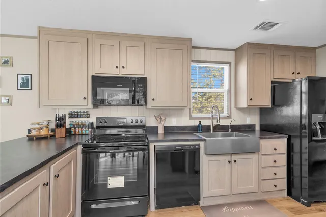 a kitchen with cabinets appliances a sink and a window
