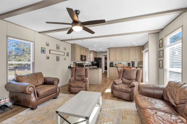 a living room with furniture kitchen view and a window