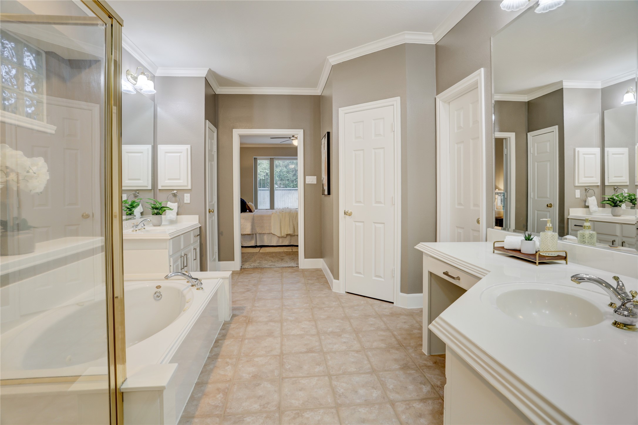 24418 Falcon Point Drive Katy, TX 77494 - Photo 16 of 40 Generously sized bathroom designed for everyday ease, featuring an extended dual-vanity layout, a dedicated sit-down vanity space, and excellent storage throughout. The separate soaking tub and walk-in shower create a functional split design, while the open layout offers a comfortable flow back into the primary bedroom.