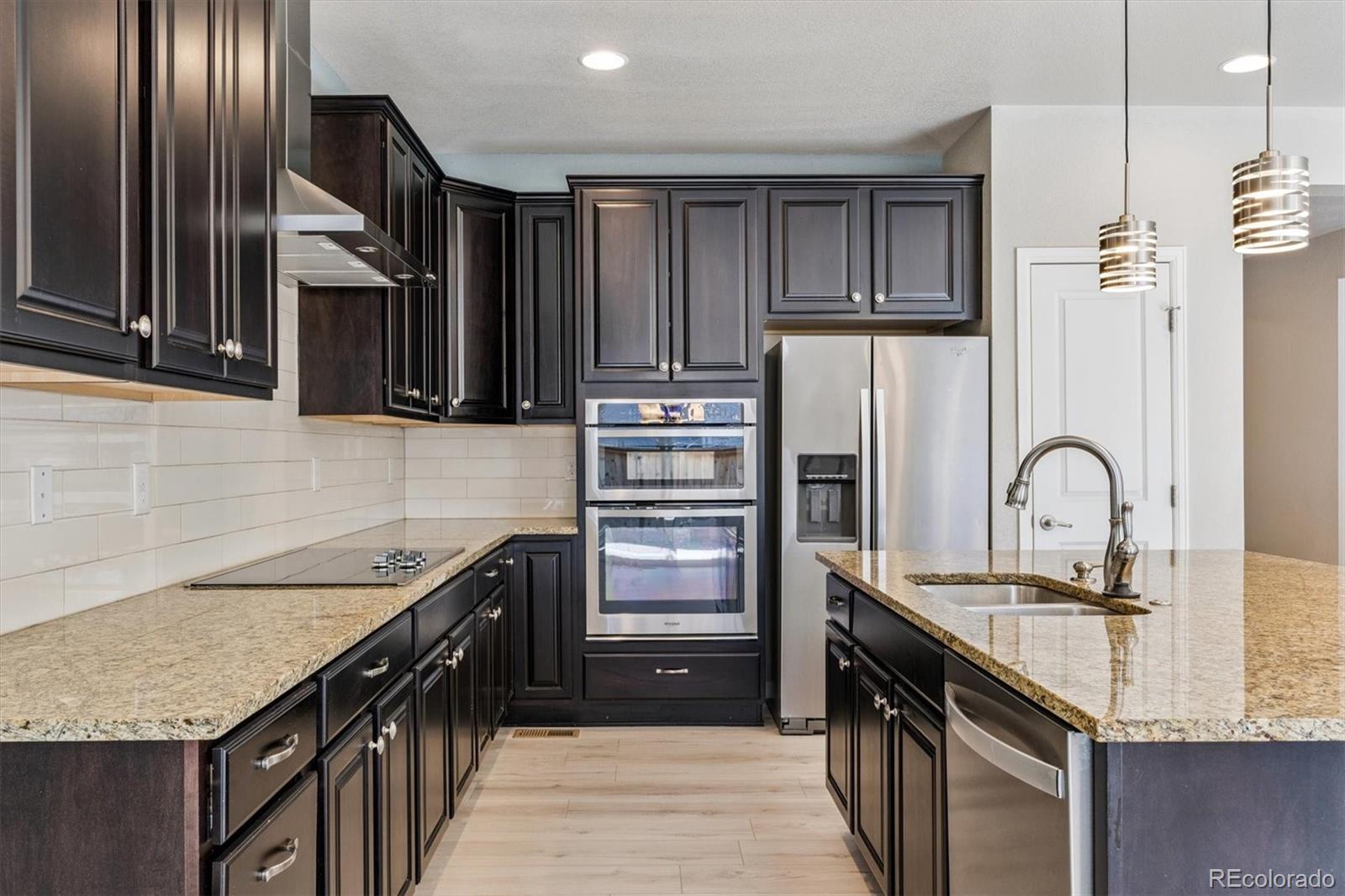 a kitchen with granite countertop stainless steel appliances and wooden cabinets