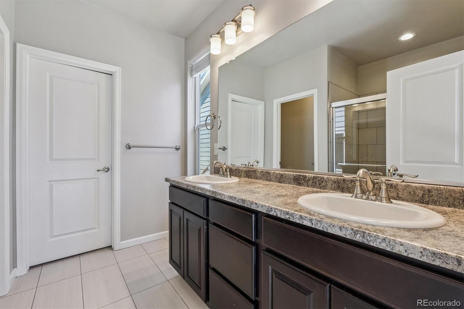 767 Wagon Bend Road Berthoud, CO 80513 - Photo 14 of 21 a bathroom with a granite countertop sink and a mirror