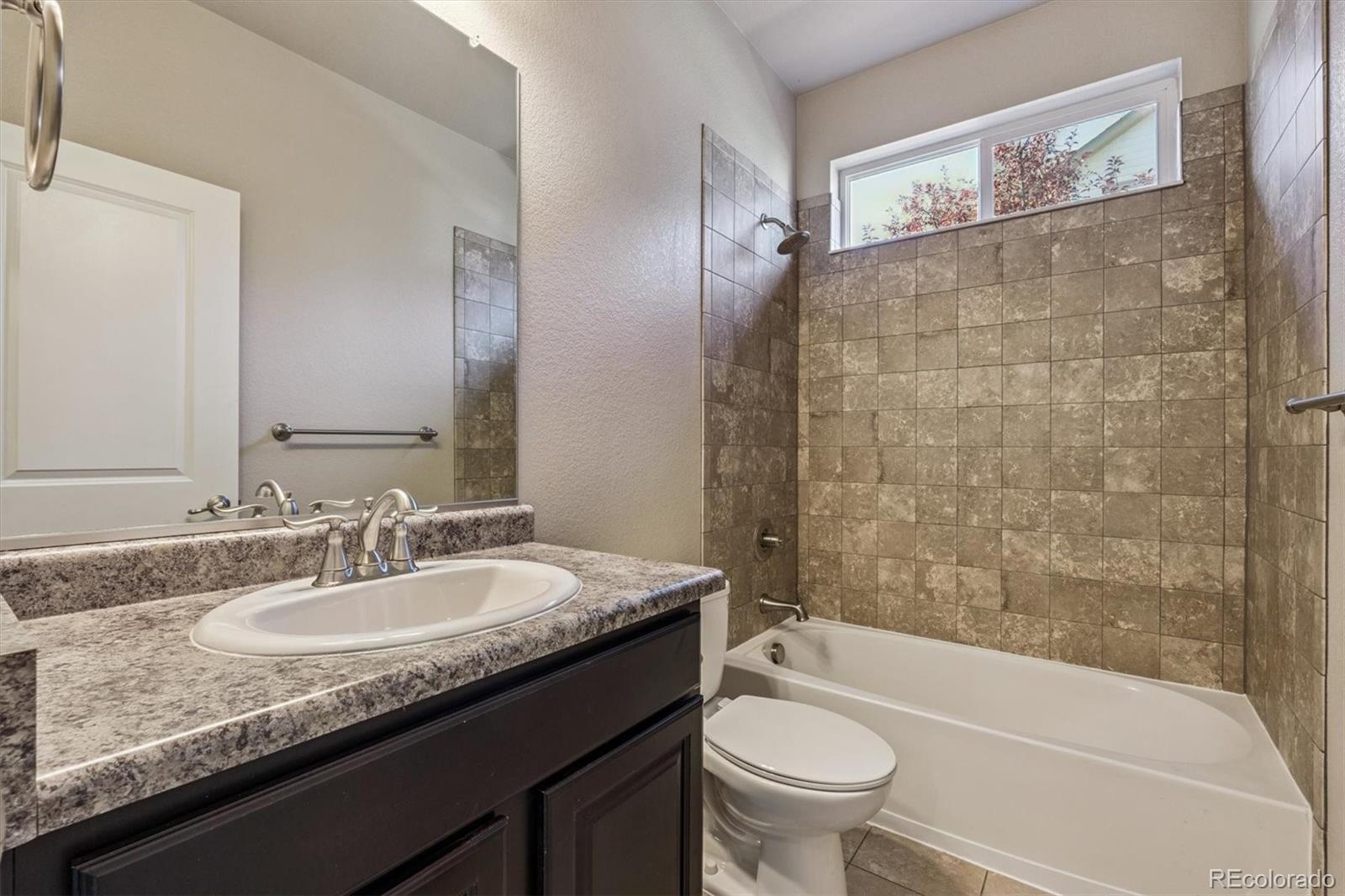 767 Wagon Bend Road Berthoud, CO 80513 - Photo 7 of 21 a bathroom with a granite countertop sink toilet mirror and bathtub