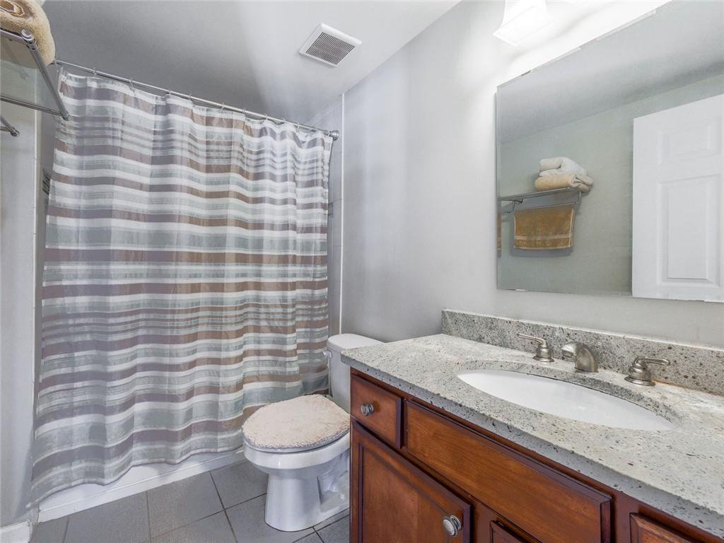 275 13th Street Northeast, Unit 1106 Atlanta, GA 30309 - Photo 12 of 22 a bathroom with a granite countertop toilet sink and mirror