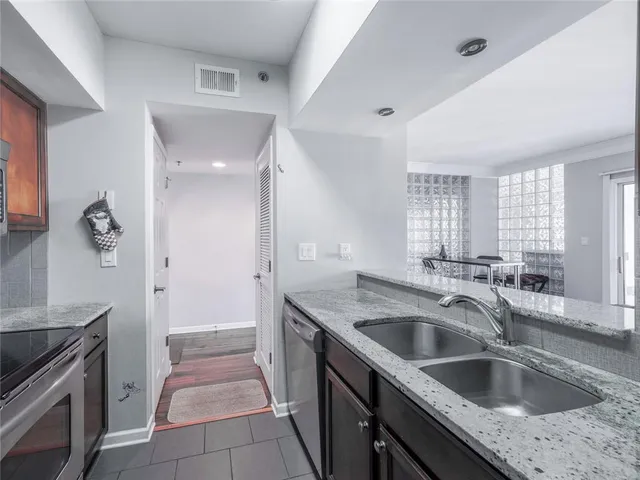 a kitchen with a sink stove top oven and refrigerator